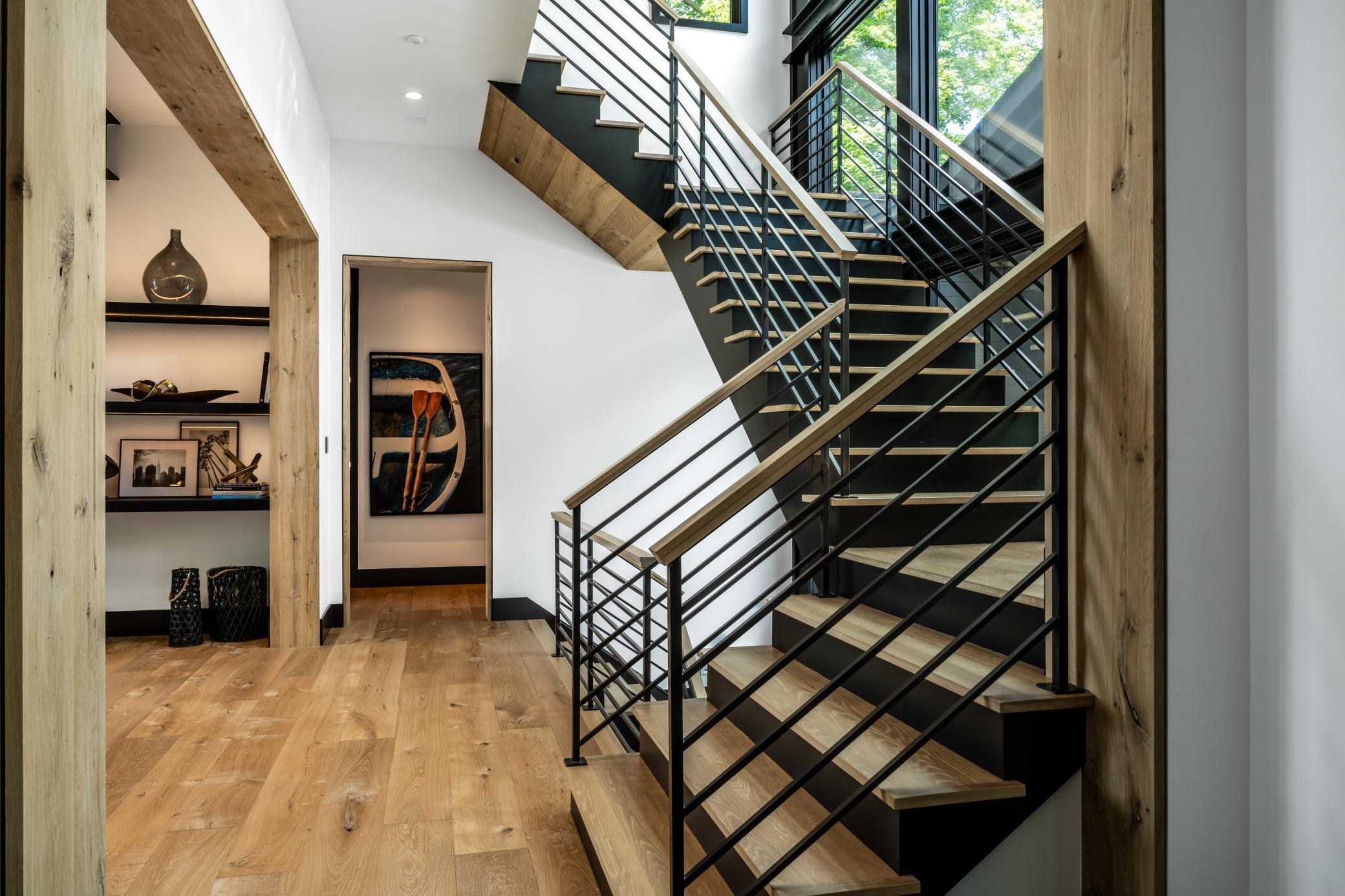 Custom open staircase with floor to ceiling windows featuring steel I-Beam