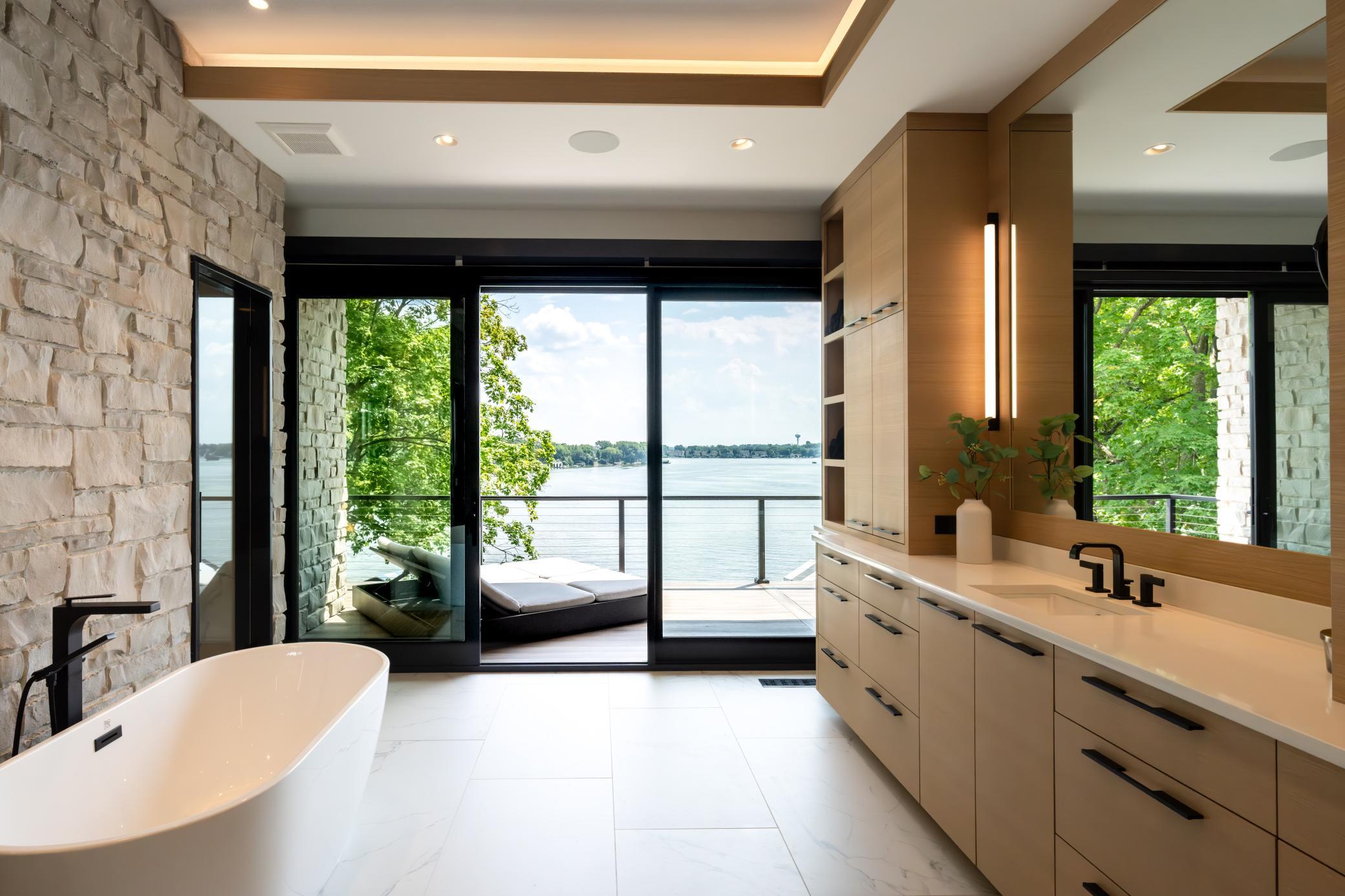 Spacious Primary Bath features two large vanities, oversized steam shower with two entrances, soaking tub and full wall Marvin slider out to a deck large enough for several seating areas