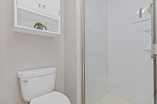 Tucked-away privacy for the toilet and a glass-enclosed shower give this bathroom a smart, functional layout.