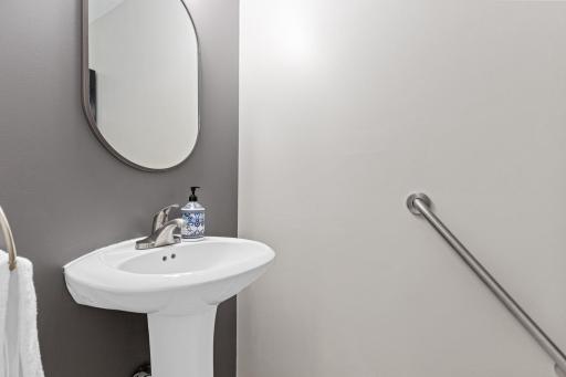 A fresh and inviting main-floor half bath featuring a neutral color palette and tasteful updates.