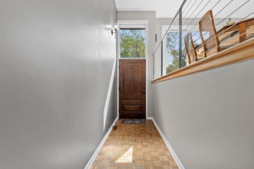 A rich wood door and classic parquet flooring welcome you into a foyer that sets the tone for the character found throughout the home.