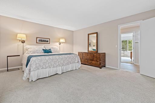 Soft carpet and neutral tones create a calming backdrop, while the expansive window brings the outdoors in.