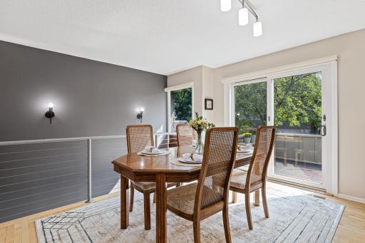 Sleek cable railing lends a contemporary touch to this open dining nook, where sliding glass doors lead straight out to the deck.