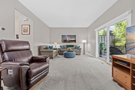 Soft carpet, soaring ceilings, and deck access make this living room an easy spot to unwind after a long day.