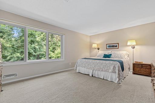 Plush carpet and a generous footprint give this primary bedroom serene, retreat-like proportions.
