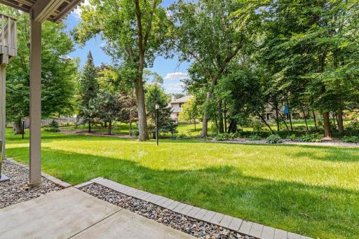 Established landscaping and towering shade trees create a lush, park-like backdrop right outside your patio door.