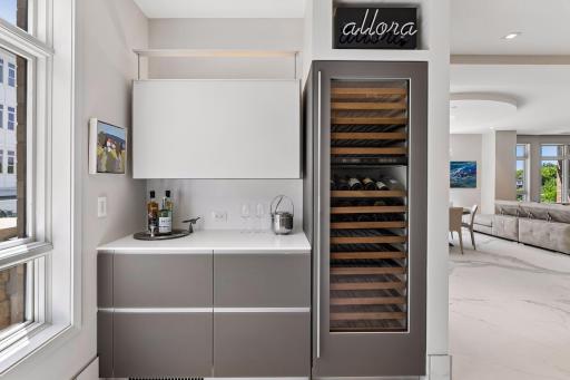 Stylish bar area off the kitchen with full beverage fridge and counter space with extra storage
