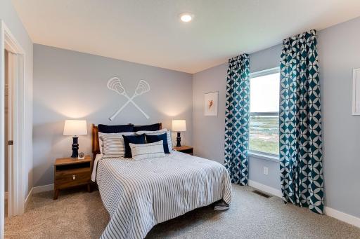 One of the secondary bedrooms with a walk-in closet. Photo of model home, colors and finishes will vary.