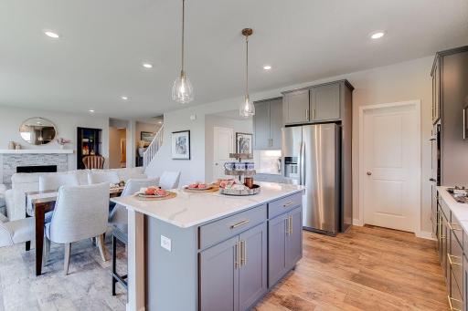 Open concept kitchen, dining, and living room. All of the kitchen cabinets include soft close doors. Photo of model home, colors and finishes will vary.