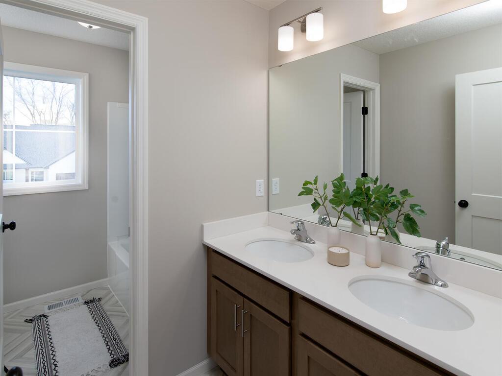 Shared bathroom with 2 sinks and a private shower/stool area