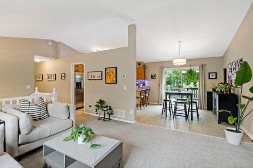The bright and inviting open-concept living room flows seamlessly into the dining area and kitchen.