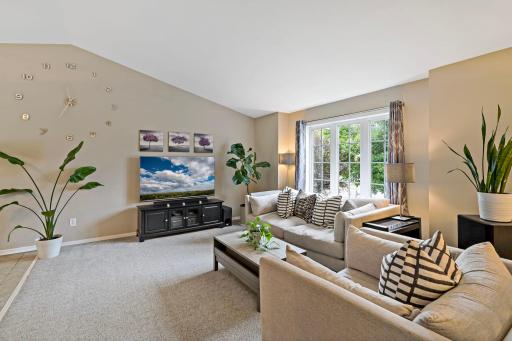 Stunning living room with vaulted ceilings, neutral decor and an abundance of natural light pouring in - you will love this space!