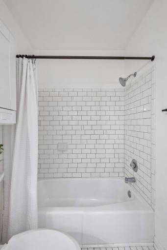 Pristine white subway tile surround in tub/shower.