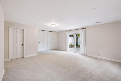 Family room has an abundance of built-in storage cabinets. Patio doors lead to a private large aggregate stone patio with a privacy fence.