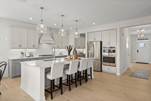 The kitchen is anchored by the large quartz kitchen island. (model photo)