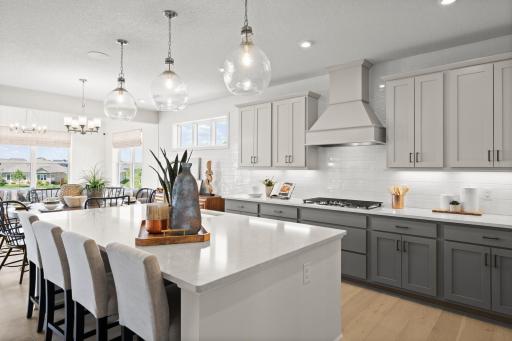 The modern kitchen is designed for both style and function, featuring stunning cabinets, quartz countertops and stainless appliances and ample storage perfect for gathering and hosting. (model photo)