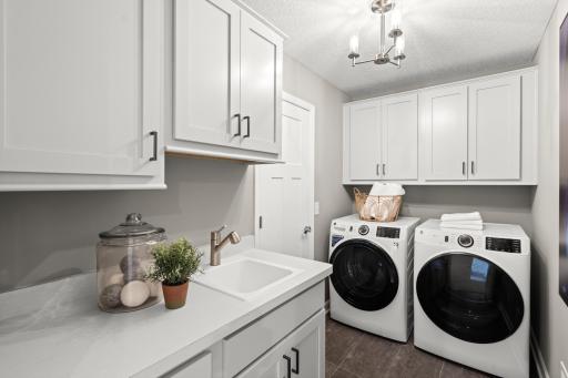 An upper level laundry is a must have, this home offers this large laundry room centrally located to all the upper level bedrooms. (model photo)