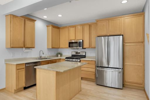 An open kitchen with band new stainless steel appliances