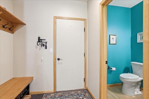 Garage entry with built in bench with hooks and 1/2 bath.