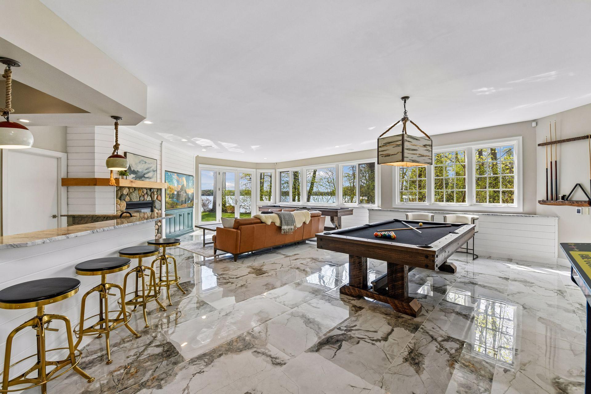 The walkout lower level is an entertainer’s dream with its family room with new flooring, gas fireplace, wet bar, billiards area, guest bedroom (or game room), and generous lakeside storage.