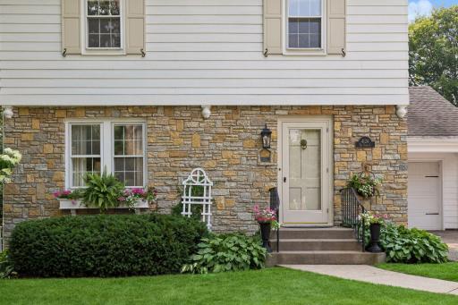 Original brick maintained exterior with distinctive stonework, classic shutters, lush landscaping, and a welcoming entry that showcases the home’s timeless character and exceptional curb appeal.