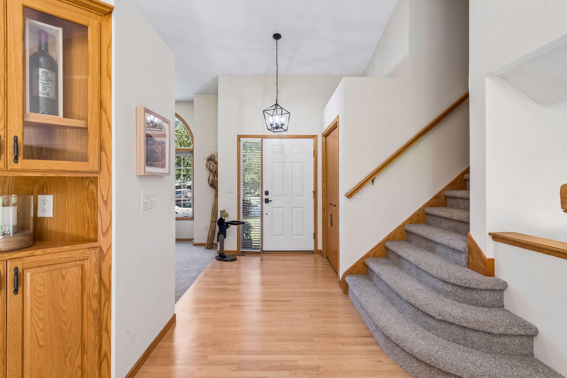 An inviting vaulted entry welcomes you with natural hardwood floors, updated lighting, and a large coat closet. From here, enjoy an open, connected layout leading to the living room, kitchen, and family room.