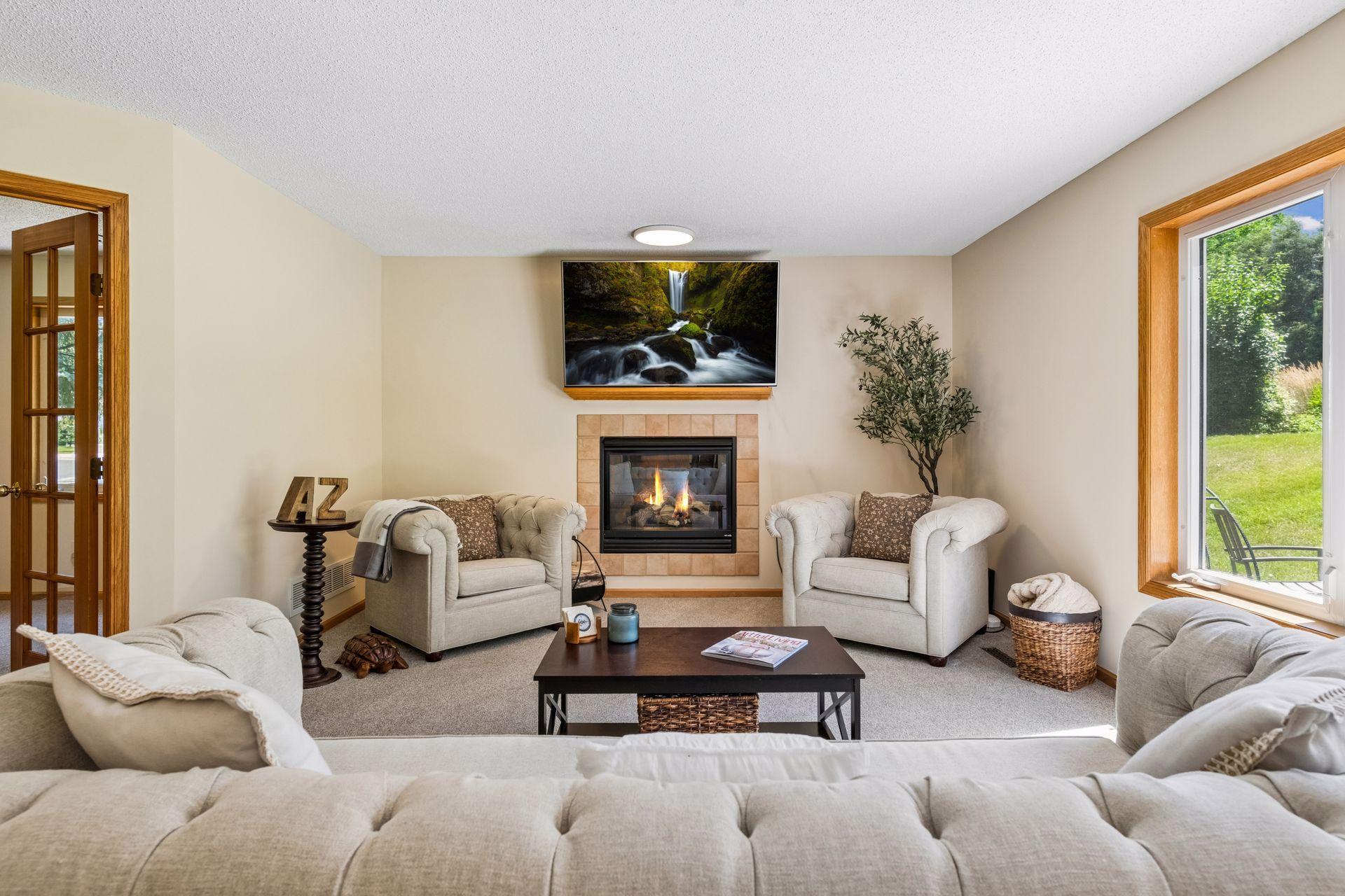Anchored by a cozy gas fireplace with a tile surround, the family room offers a warm and inviting gathering space with comfortable seating and abundant natural light.