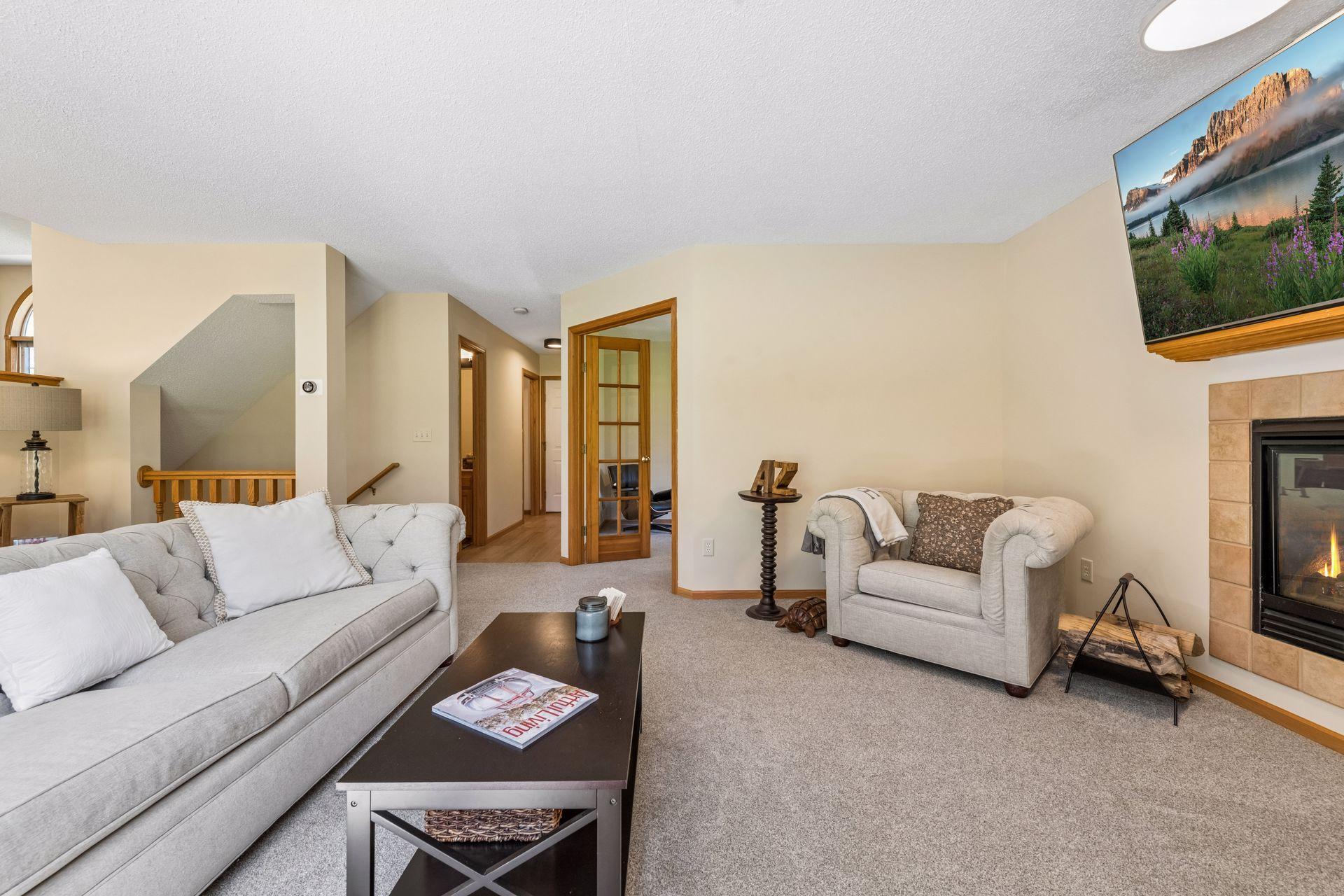 The hallway off the family room features durable and stylish new LVP flooring and provides convenient access to the main floor half bath, laundry room, attached two-car garage, and stairwell leading to the unfinished lower level.