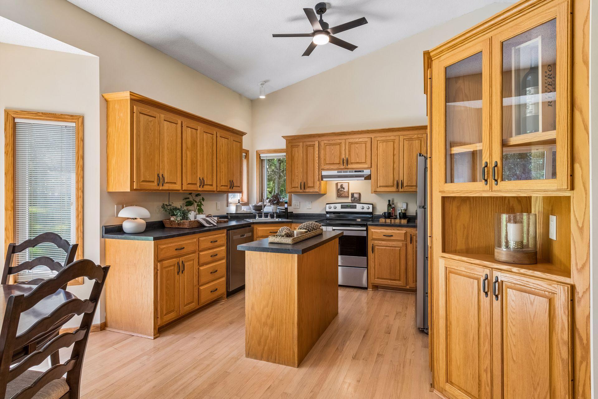 The spacious kitchen offers abundant cabinetry, a center island for added prep space, and a beautiful glass display cabinet, combining generous storage with timeless style.