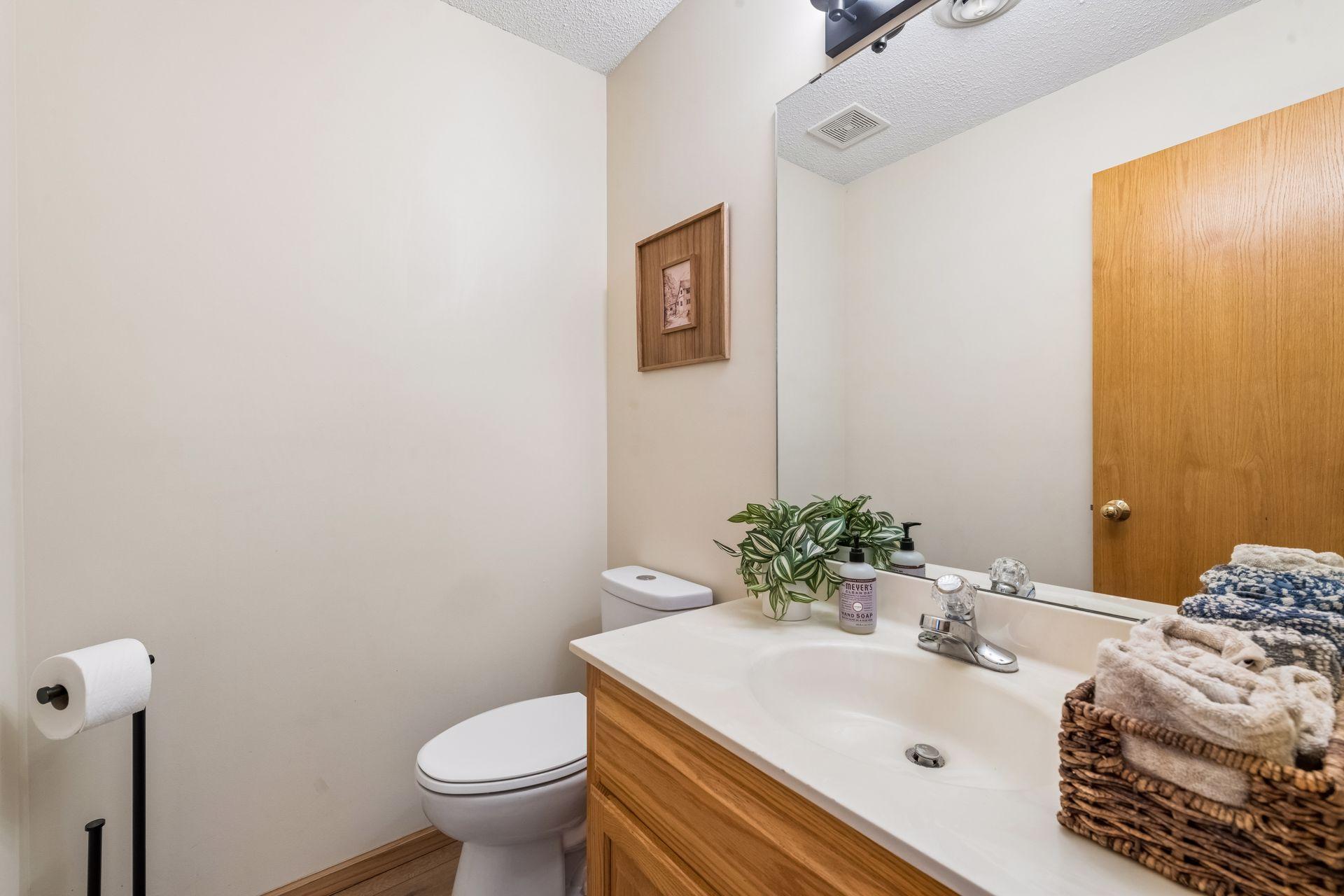 The main floor half bath combines convenience with updated lighting, making it a practical addition for guests and daily use.