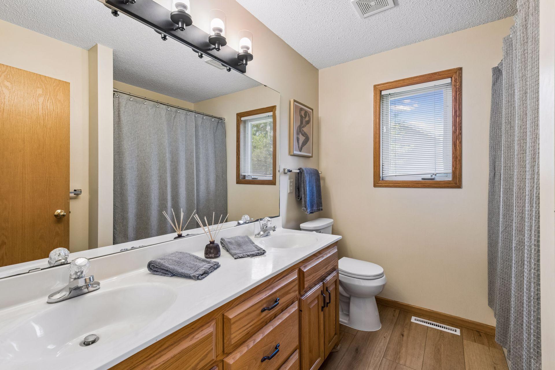 Designed for everyday convenience, the full primary bath includes a dual-sink vanity, updated lighting, new LVT flooring, and a window for natural light.