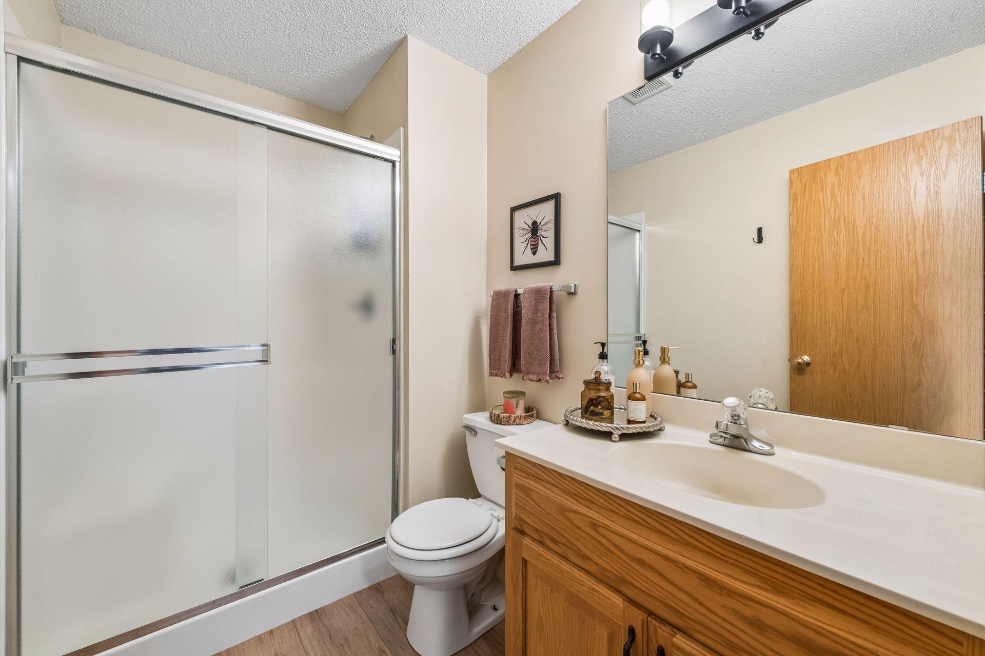 The upper-level 3/4 bath conveniently serves two secondary bedrooms and features updated LVT flooring, a new light fixture, and a walk-in shower.