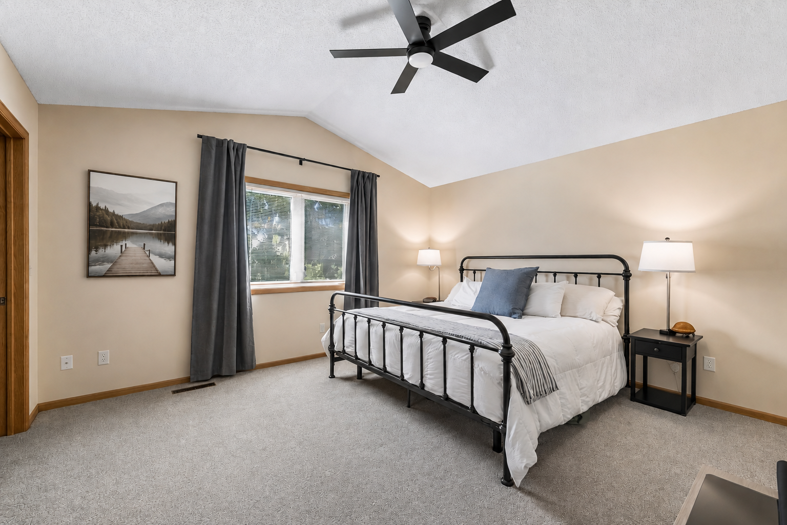 The vaulted primary suite offers generous proportions with ample space for a king-sized bed and complementary furnishings, making it a relaxing place to unwind.