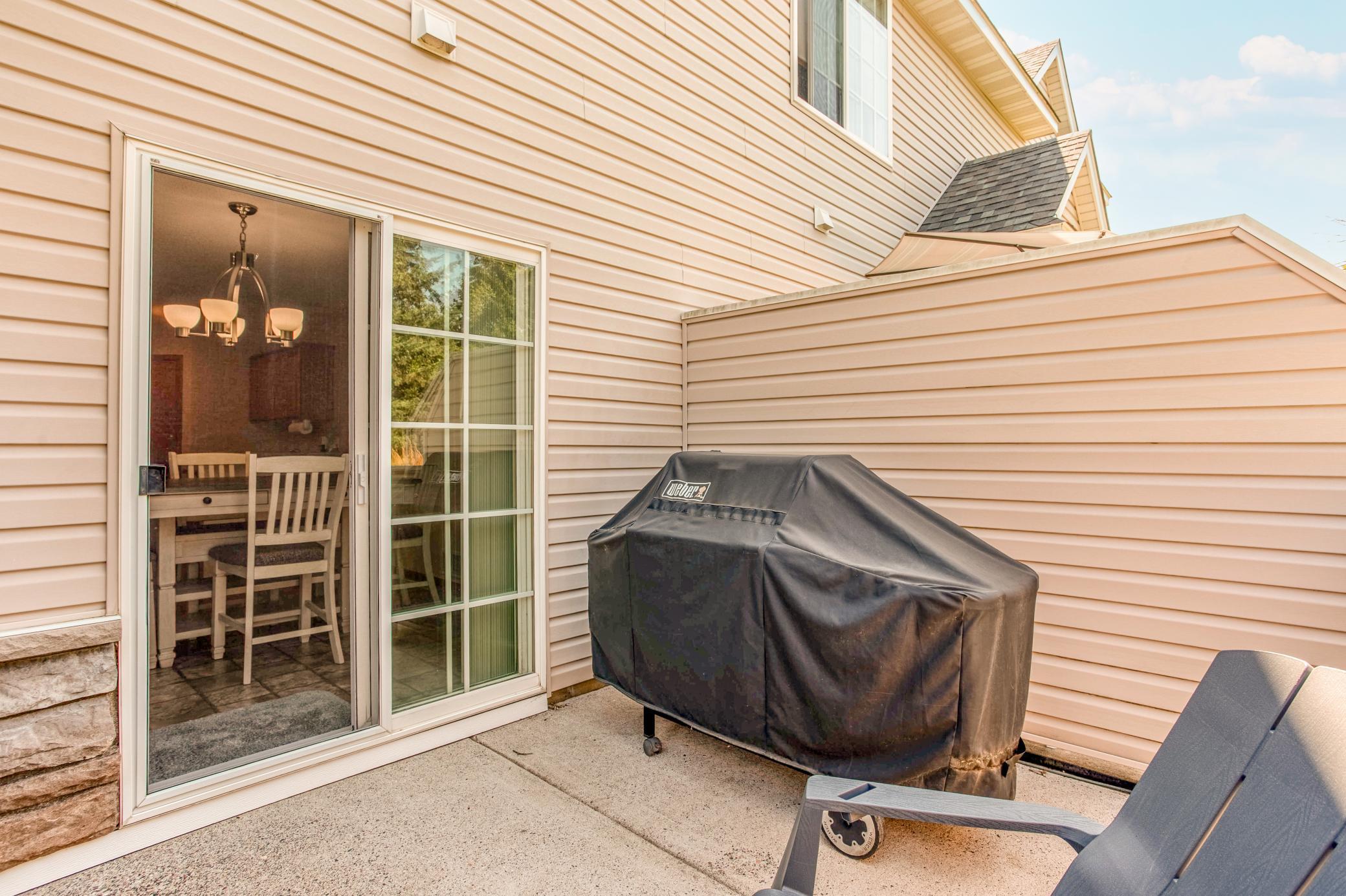 Enjoy outdoor living from the private patio, surrounded by privacy walls and overlooking mature evergreens.