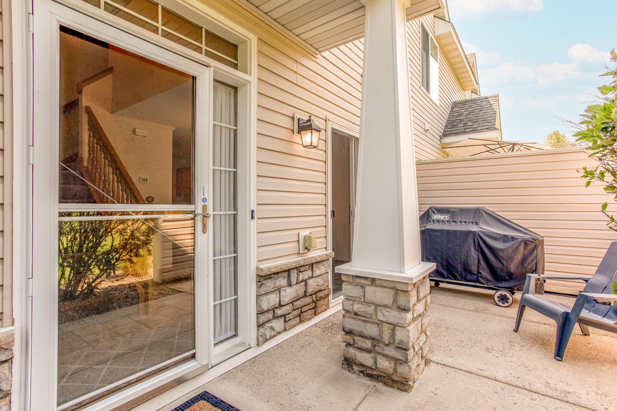 Covered entry with stone accents opens to the private patio, offering a welcoming transition into the home.
