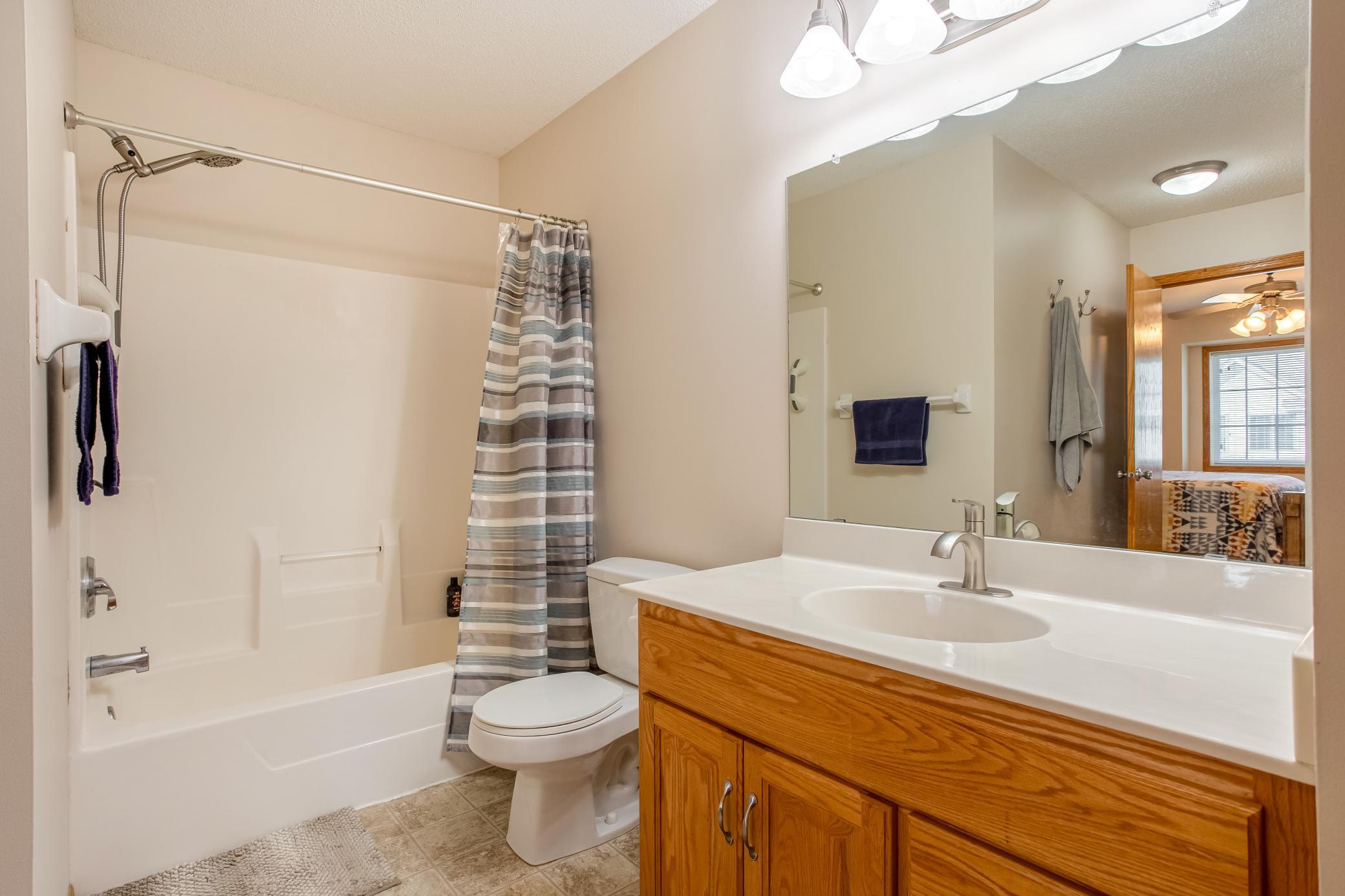 Walk-through primary bath features a tub/shower combination, spacious vanity, and direct connection to the primary suite.