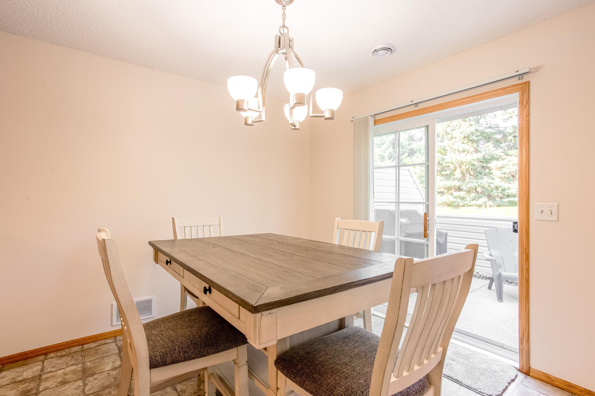 Inviting dining space features direct patio access, bringing natural light and the private outdoor backdrop into view.