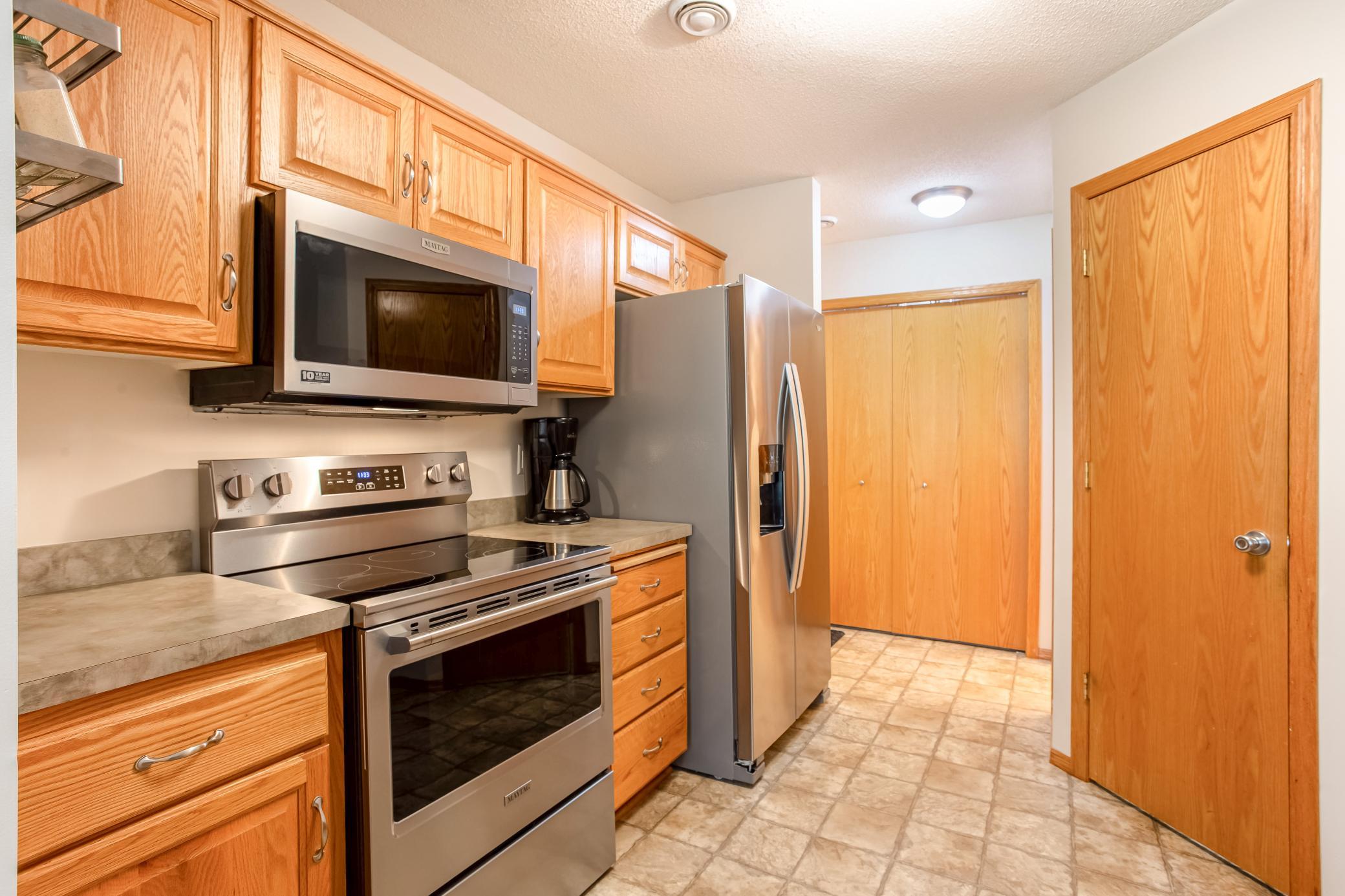 Well-appointed kitchen with abundant oak cabinetry, stainless-steel appliances, plus a brand-new range and microwave.