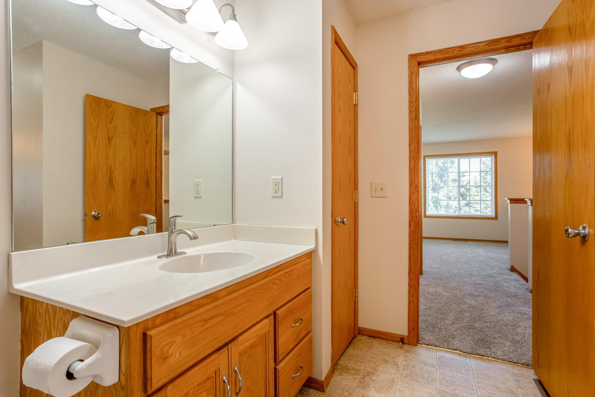 The walk-through bath design provides convenient access between the primary bedroom and upper-level living spaces.