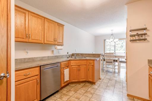 Functional kitchen layout offers generous cabinet and counter space, stainless-steel dishwasher, and an easy connection to the dining area.