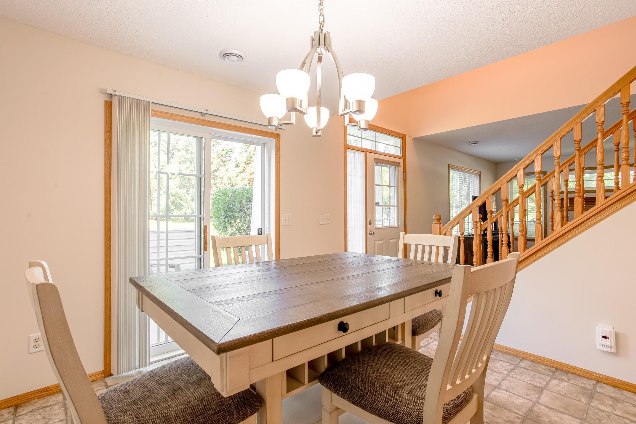 Bright dining area with updated lighting and easy flow to the kitchen, living room, and private patio.