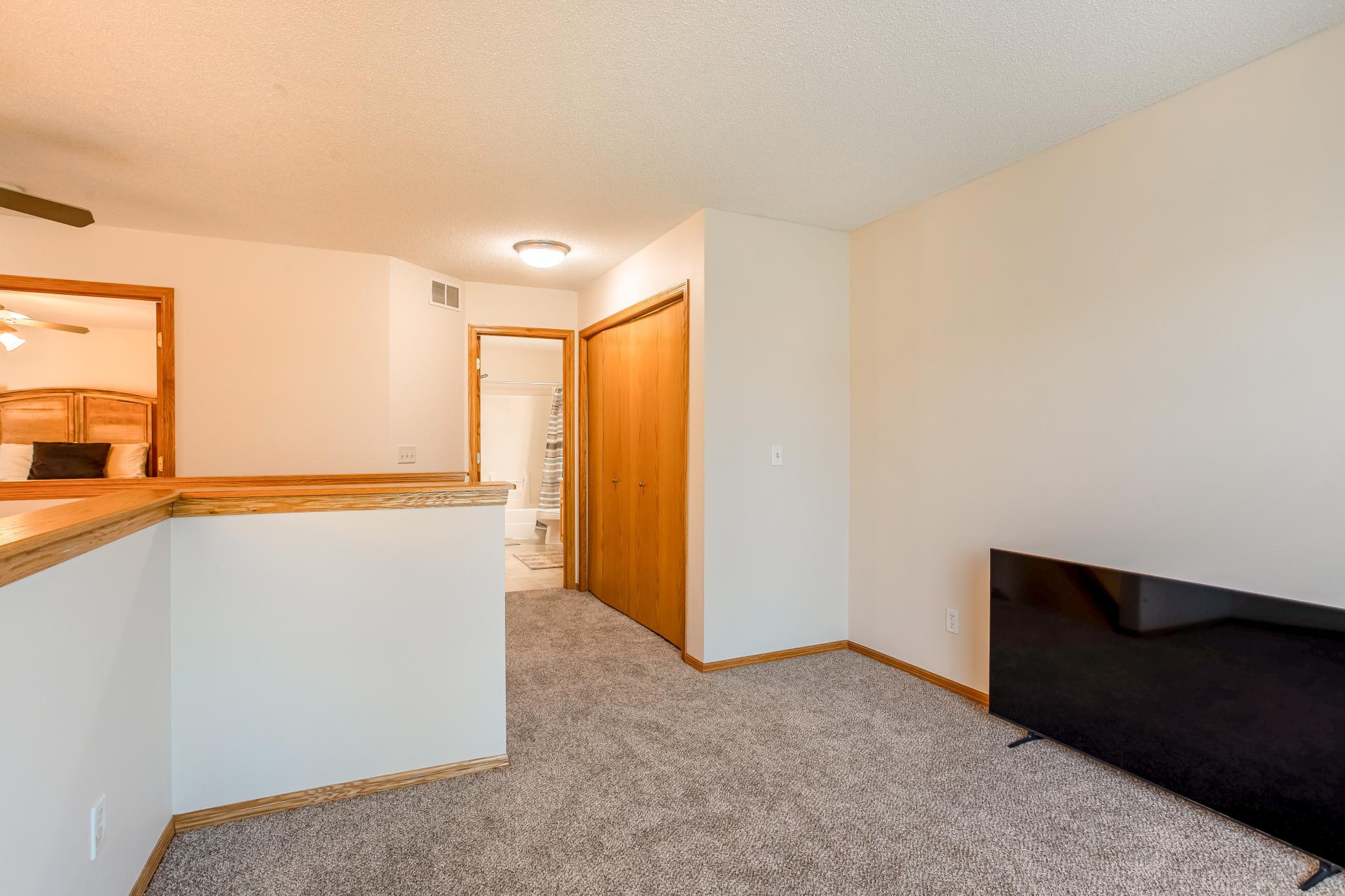 Another view of the versatile loft, featuring brand-new carpet and convenient access to the nearby bedrooms and bath.