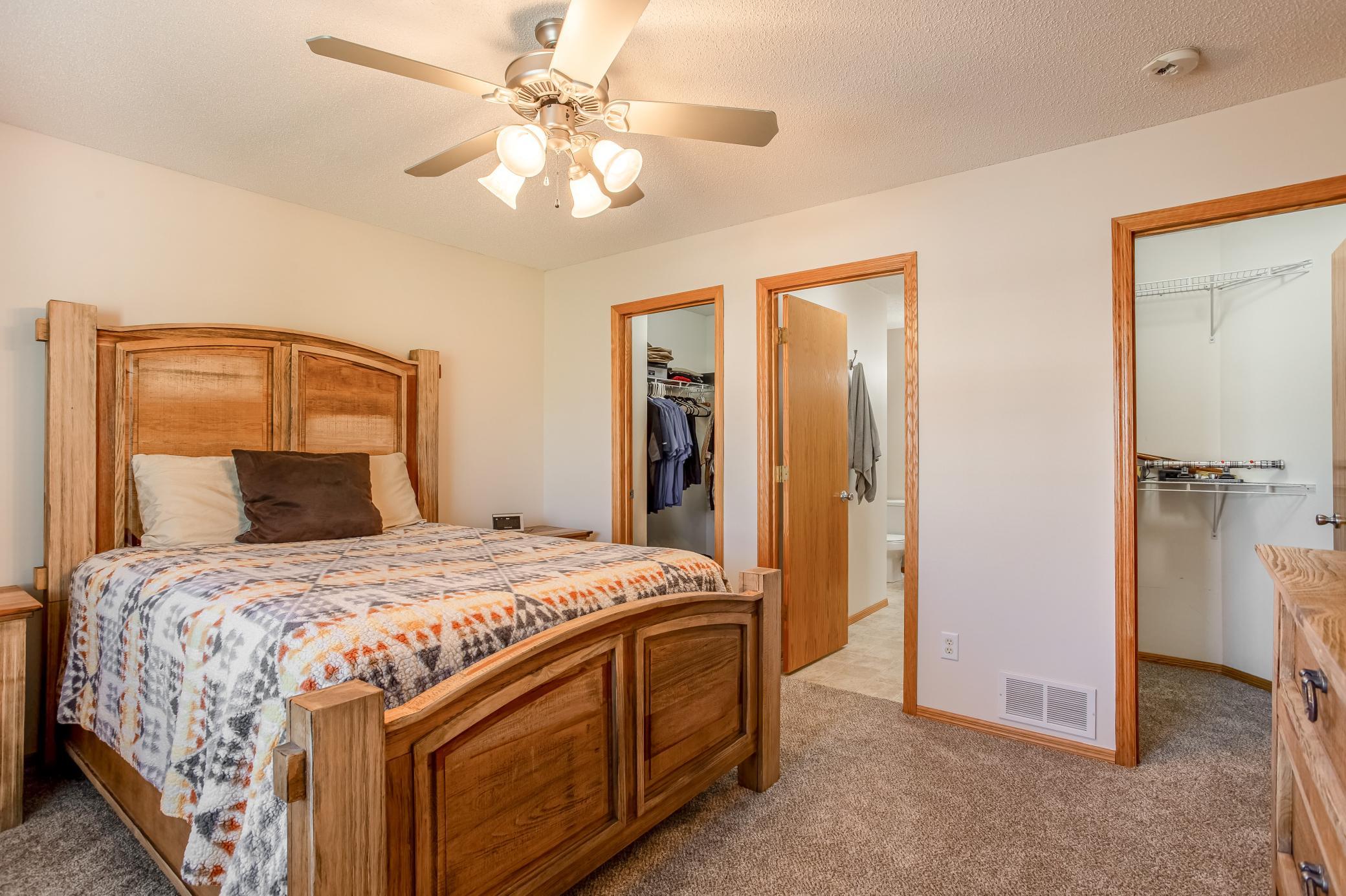 Spacious primary suite features brand-new carpet and convenient access to dual walk-in closets and the walk-through bath.