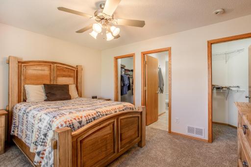 Spacious primary suite features brand-new carpet and convenient access to dual walk-in closets and the walk-through bath.