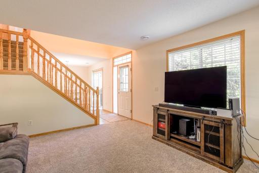 Open living area flows toward the front entry and staircase, with a large picture window bringing in plenty of natural light.