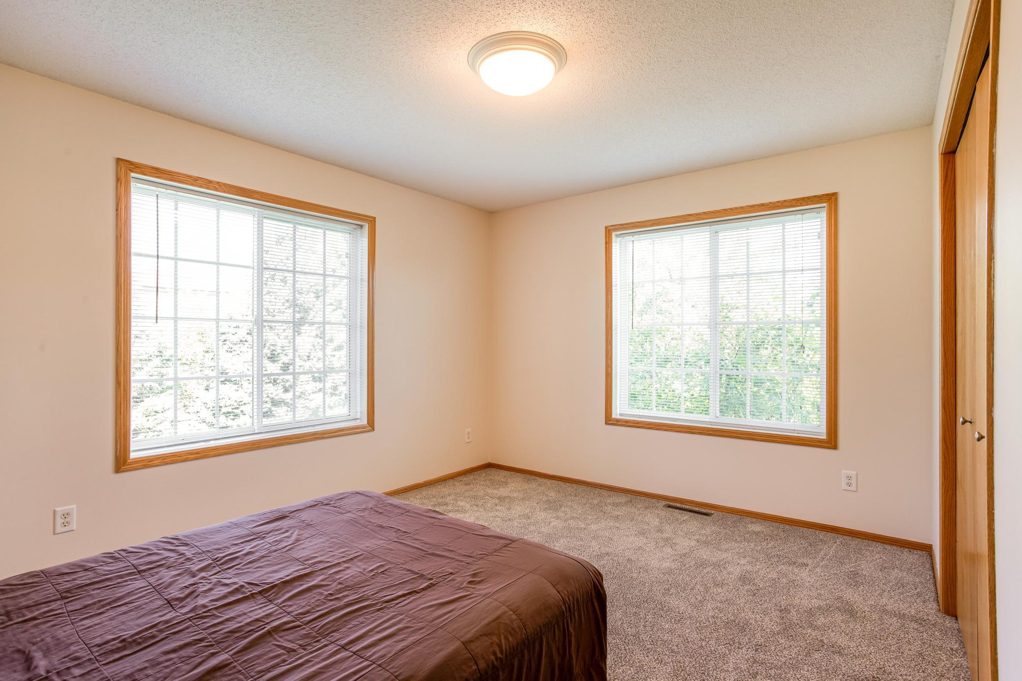 Bright secondary bedroom features brand-new carpet and two large windows for plentiful natural light.