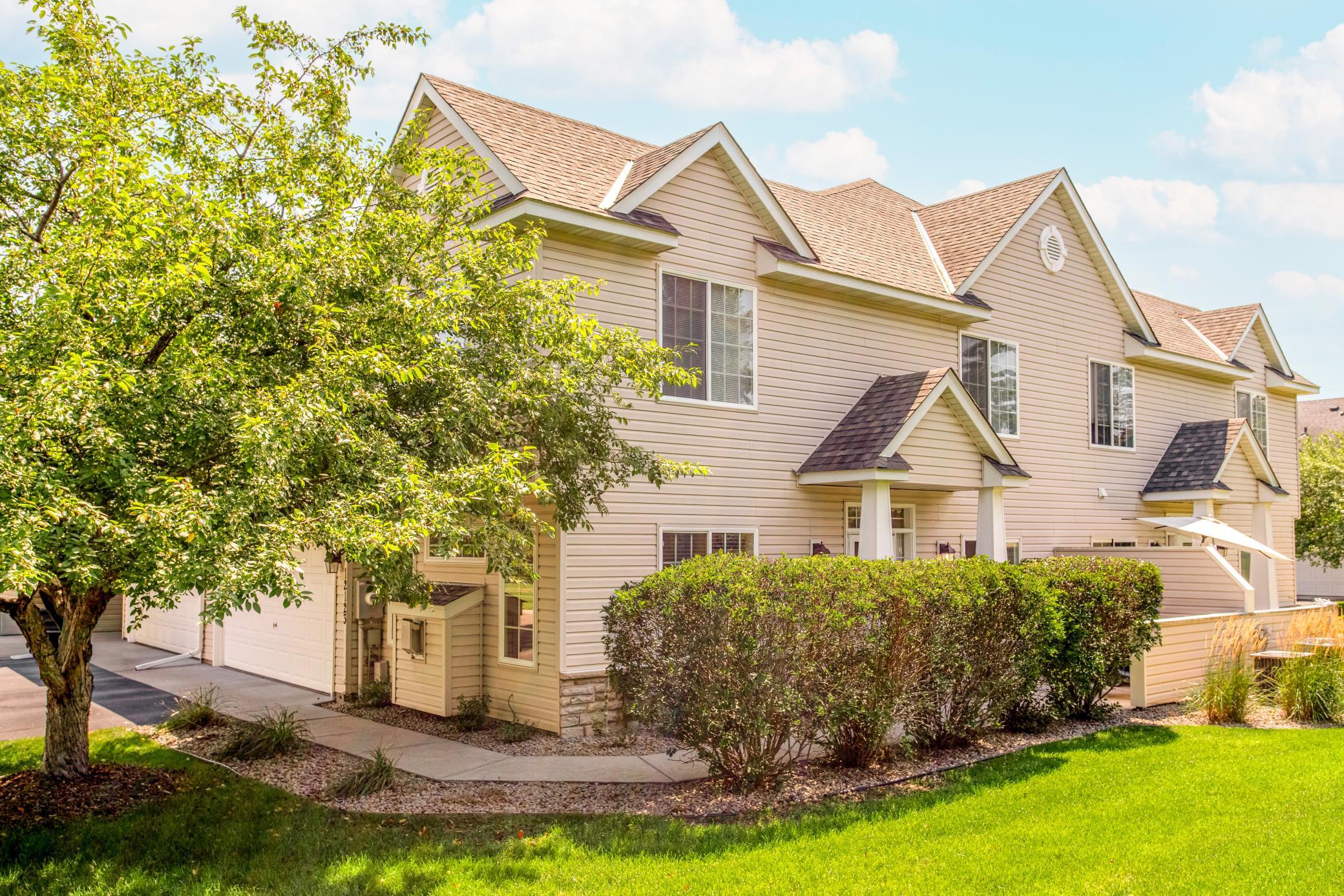 Prime end-unit townhome surrounded by mature landscaping and lush green space for a welcoming, private setting.