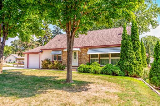 Another inviting view of the home's charming exterior, framed by mature trees and manicured landscaping on this prime corner lot.
