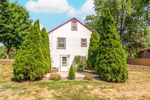 The home's private patio is tucked between mature Arborvitae trees, creating a peaceful and secluded space for relaxing or entertaining outdoors.