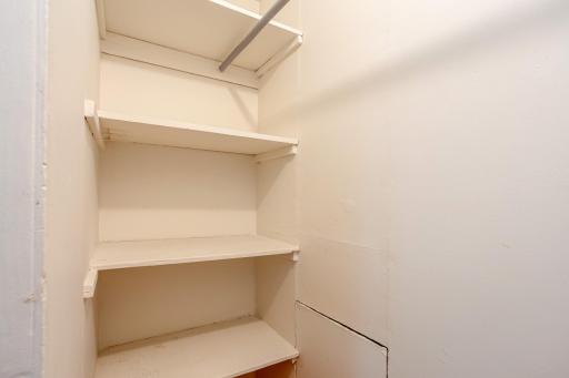 Convenient built-in storage provides multiple shelves and hanging space for organized everyday essentials near the stairs leading to the upper-level.